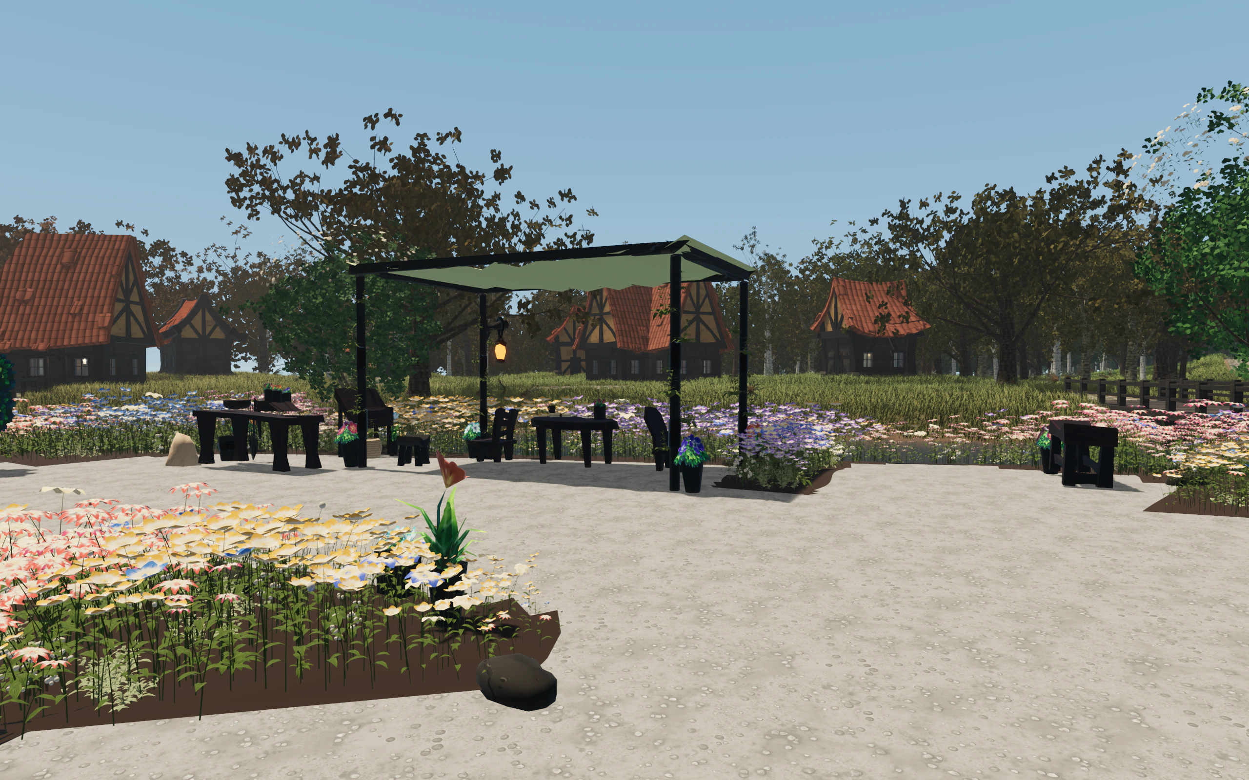 Tables and chairs beneath a green canopy, surrounded by flower beds on Pietraluce’s terrace